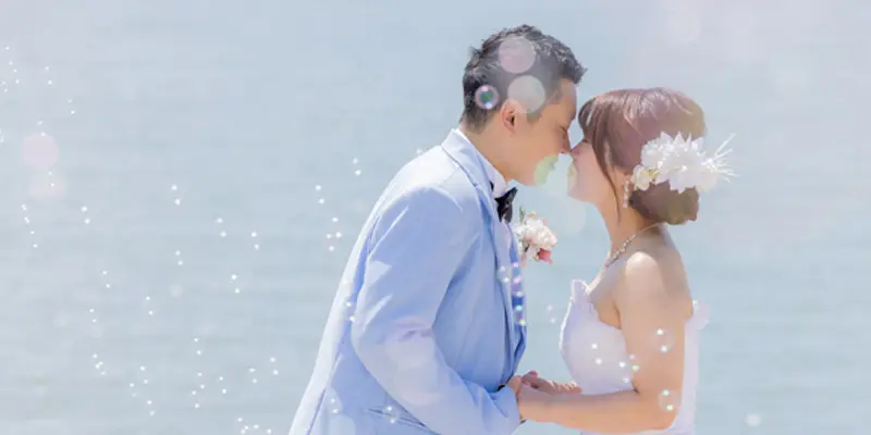 スタジオグッドが提供する結婚式の前撮りのロケーション撮影|瀬戸内海の美しい自然を背景にウェディングドレスを纏った純白の花嫁と白いタキシートをまとった新郎が佇んでいる